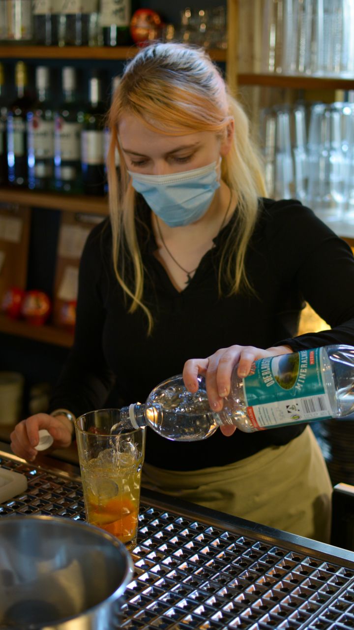 Mitarbeiterin von umaii ramen restaurant bereitet Getränke vor